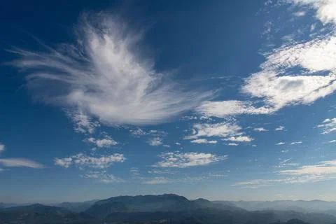 A dramatic swirling cirrus cloud formation spreads across a deep blue sky a.. 写真素材
