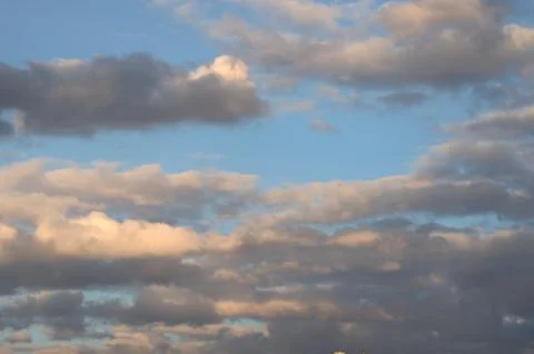 Dramatic thunder clouds against the blue sky on a sunset. Cloudscape. Stock Photos