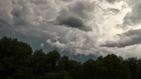 Dramatic thunderclouds slowly move across the sky above the forest Stock Footage 247721511