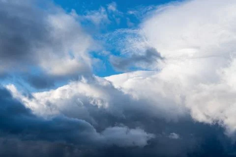 Dramatic thunderstorm clouds floating in blue sky before rain. Majestic Stock Photos