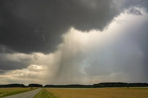 Dramatic thunderstorm clouds producing a heavy rain shaft Stock Photos