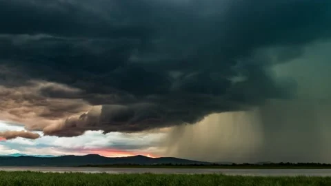 Dramatic thunderstorm with lightning over the lake during sunset, timelapse Stock Footage 144312439