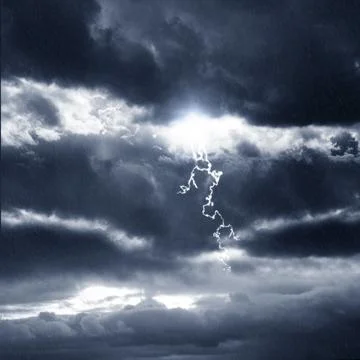 Dramatic thunderstorm scene featuring dark, heavy rain clouds, a bright fla.. Stock Photos