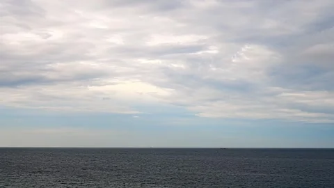 Dramatic Time-lapse of Clouds Moving Over the Ocean with Distant Ship Stock Footage 327838477