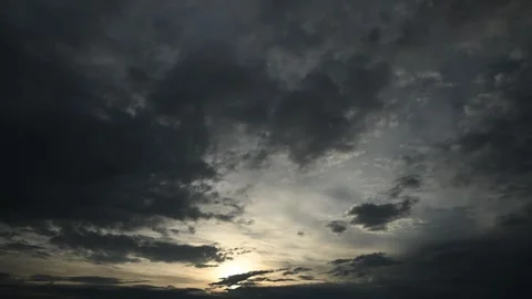 Dramatic time lapse of dark gray late day clouds with the sun near the horizon Stock Footage 263251930