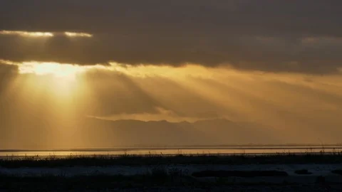 Dramatic time-lapse with sun rays breaking through rolling clouds, golden Stock Footage 119937034