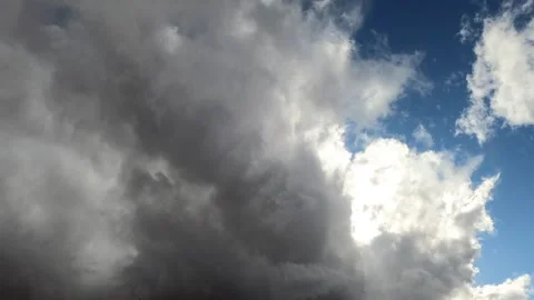 Dramatic time lapse of thick white and grey clouds moving across blue sky d.. Stock Footage 337596606