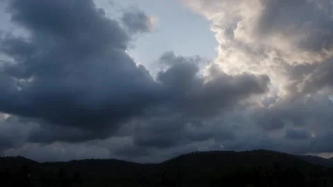 Dramatic timelapse of dark storm clouds moving over tropical hills Video stock 348485989