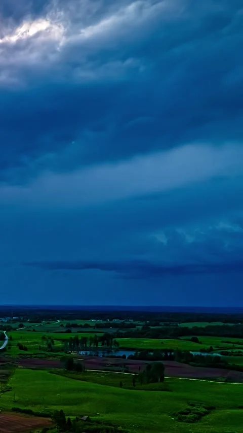 Dramatic Timelapse of Stormy Skies Over Lush Green Fields Stockbeeldmateriaal 317625224