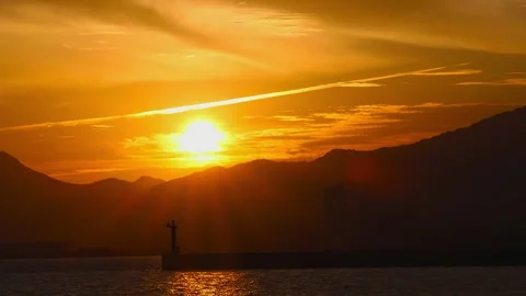 Dramatic timelapse sunset with an airplane cloud and a lighthouse in Japan,4K Stock Footage 347597188