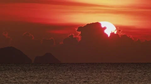 Dramatic Tropical Sunset with Giant Sun Behind Clouds and Island Silhouettes 库存影片 333605810