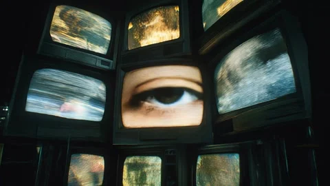 Dramatic TVs stacked on black, central screen shows close-up of an eye. Video stock 315510528