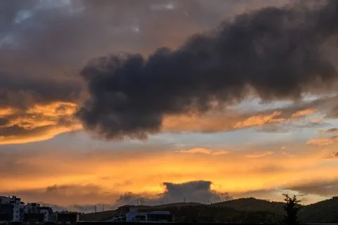 Dramatic Twilight Sky with Dark and Golden Clouds, Deep Blue to Orange Suns.. Stock Photos
