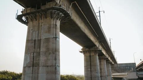 Dramatic underpass view of towering concrete bridges against the sky, captu.. Stock Photos