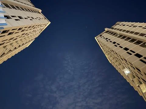 Dramatic upward angle night shot between two tall buildings Stock Photos
