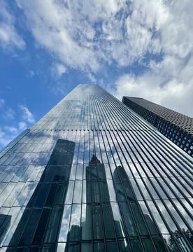 Dramatic upward view of a modern glass and steel building against a blue sky Stock Photos