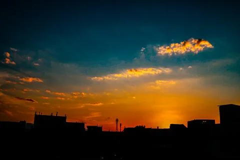 Dramatic urban sunset with deep orange and blue gradient sky Stock Photos