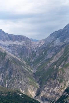 Dramatic V-shaped alpine valley with steep green slopes Stock Photos