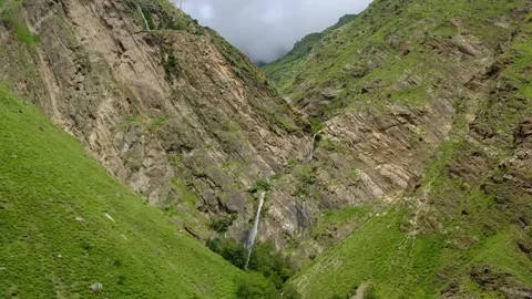 Dramatic V-Shaped Mountain Valley with Cascading Waterfalls and Lush Vegetation Video stock 315068645