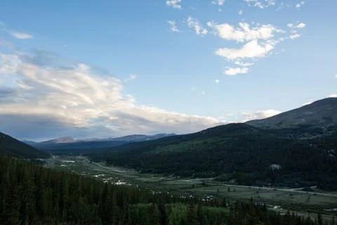 Dramatic valley scene under blue sky and vibrant clouds Stock Photos
