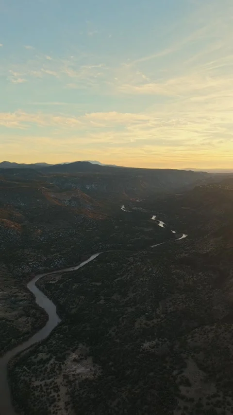Dramatic Vertical Drone 4K Pull Back Revealing Serpentine River in Rugged Stock Footage 325786287