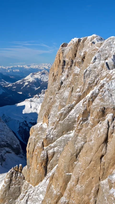 Dramatic vertical pan reveals vast snow-capped mountain range under clear b.. Vídeos de archivo 335186005