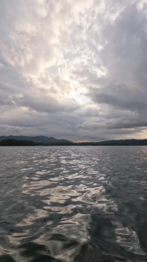 Dramatic vertical timelapse of clouds moving fast over a lake Stock Footage 320029675