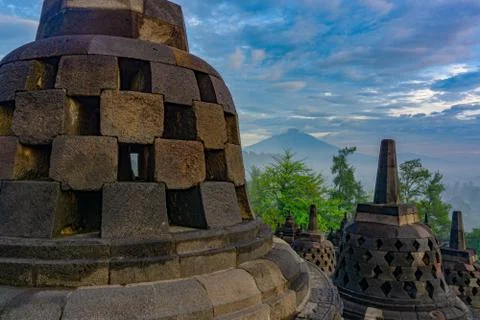 Dramatic view of ancient stupa borobudur temple with Mount Merapi in backgrou Stock Photos