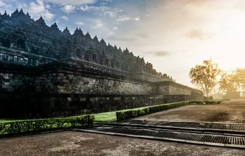 Dramatic view of ancient stupa borobudur temple with ray sunrise in the morni Stock Photos