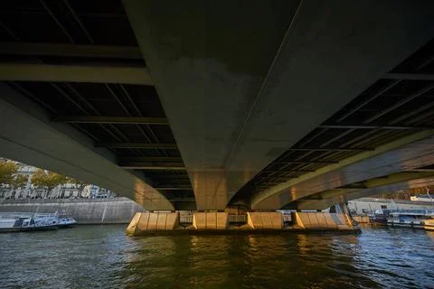 Dramatic view from beneath a large bridge over the Seine River in Paris 스톡 사진