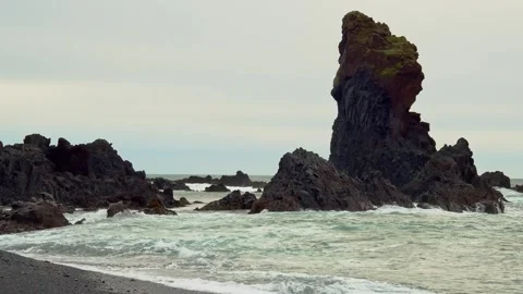 Dramatic view of the black sand beach and volcanic rock formations of Djúpalónss Stock Footage 320228724