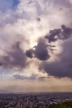 Dramatic view of clouds with sun rays over the city Stock Photos