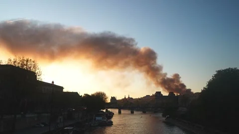 Dramatic view of a column of smoke in Paris by the Seine River at sunset Stock Footage 312872599