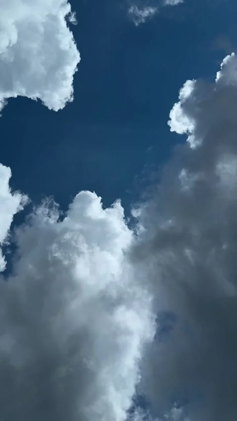 Dramatic view of fluffy clouds framing a deep blue sky with scattered sunligh Stock Footage 338414409
