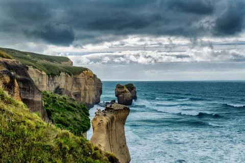 Dramatic view of high sandy cliffs at Tunnel beach, Otago, New Zealand Stock Photos