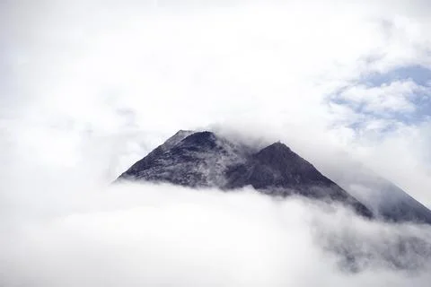 The dramatic view of Mount Merapi covered in clouds is very dense. Mountain.. Stock Photos