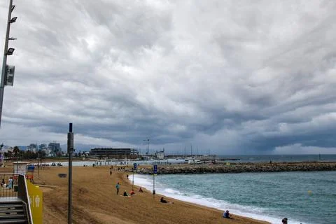 A dramatic view of a sandy beach under a cloudy, stormy sky Foto stock