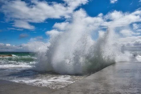 Dramatic view of sea waves crashing against the concrete pier Stock Photos