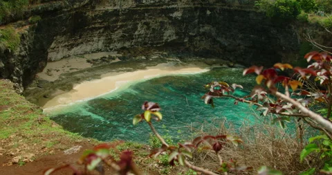 Dramatic view secluded beach turquoise water ocean rocky cliffs surrounding cove Video stock 327495435