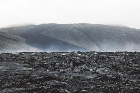 Dramatic view of still hot lava rocks and steam rising from the hot grounds Stock Photos