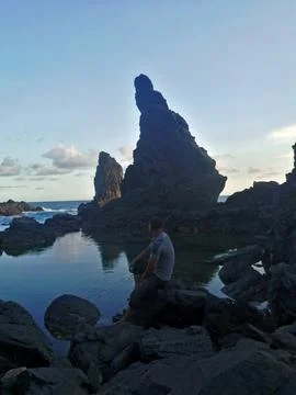 Dramatic view of volcanic sea stacks perfectly reflected in a tidal pond. Photos