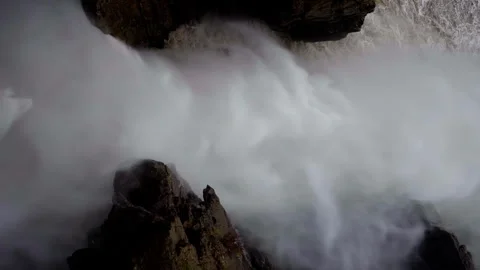 Dramatic view of a waterfall's might enveloping the rocks in mist, showcasing Stock Footage 265897675