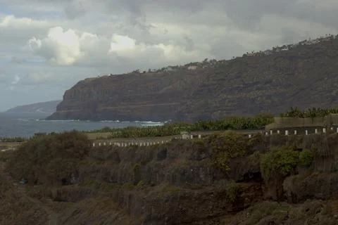 Dramatic Volcanic Cliffs and Ocean Coastline with Lush Vegetation and banan.. Stock Photos