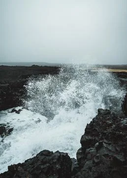Dramatic Volcanic Coastline with Ocean Waves and Dark Basalt Cliffs in Icelan Stock Photos