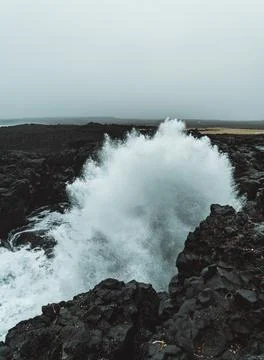 Dramatic Volcanic Coastline with Ocean Waves and Dark Basalt Cliffs in Icelan Stock Photos