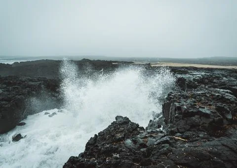 Dramatic Volcanic Coastline with Ocean Waves and Dark Basalt Cliffs in Icelan Stock Photos