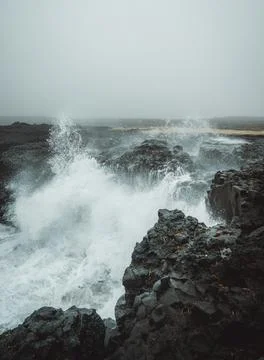Dramatic Volcanic Coastline with Ocean Waves and Dark Basalt Cliffs in Icelan Stock Photos