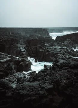 Dramatic Volcanic Coastline with Ocean Waves and Dark Basalt Cliffs in Icelan Stock Photos