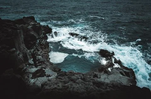 Dramatic Volcanic Coastline with Ocean Waves and Dark Basalt Cliffs in Icelan Stock Photos