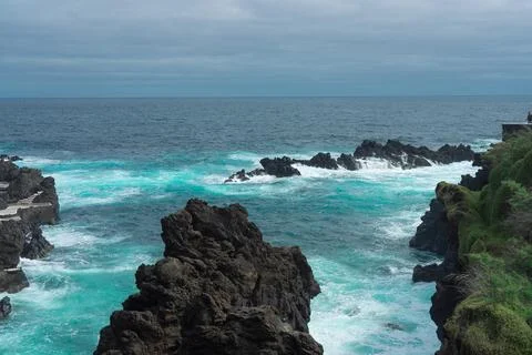 Dramatic Volcanic Coastline with Turquoise Ocean Waves Crashing Against Rug.. Stock Photos
